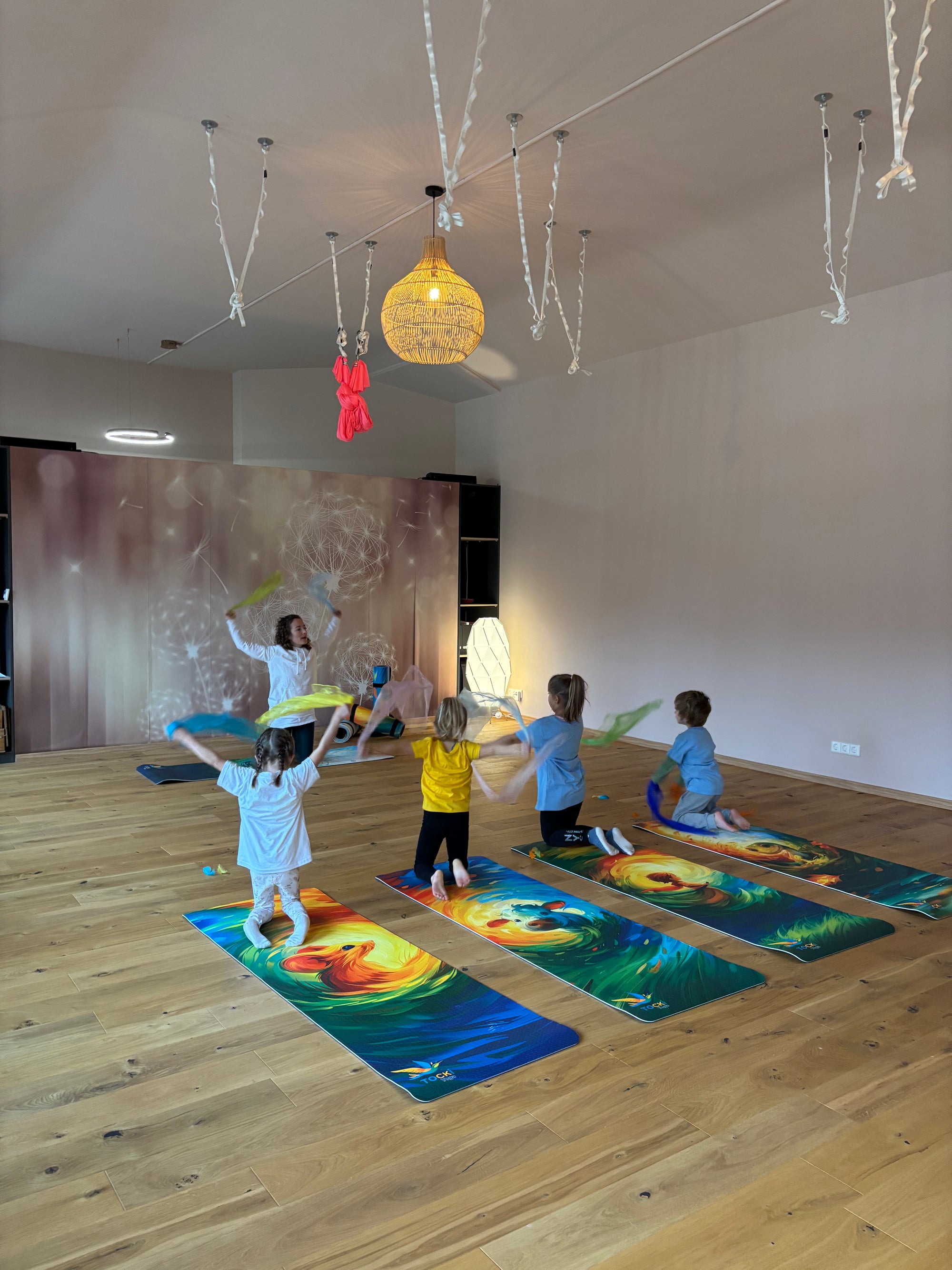 TOCKI Kinderyogamatten – Ein Kind in einem fröhlichen Yoga-Gruppenkurs, das auf der rutschfesten Yogamatte mit einem lustigen Maus-Motiv übt.